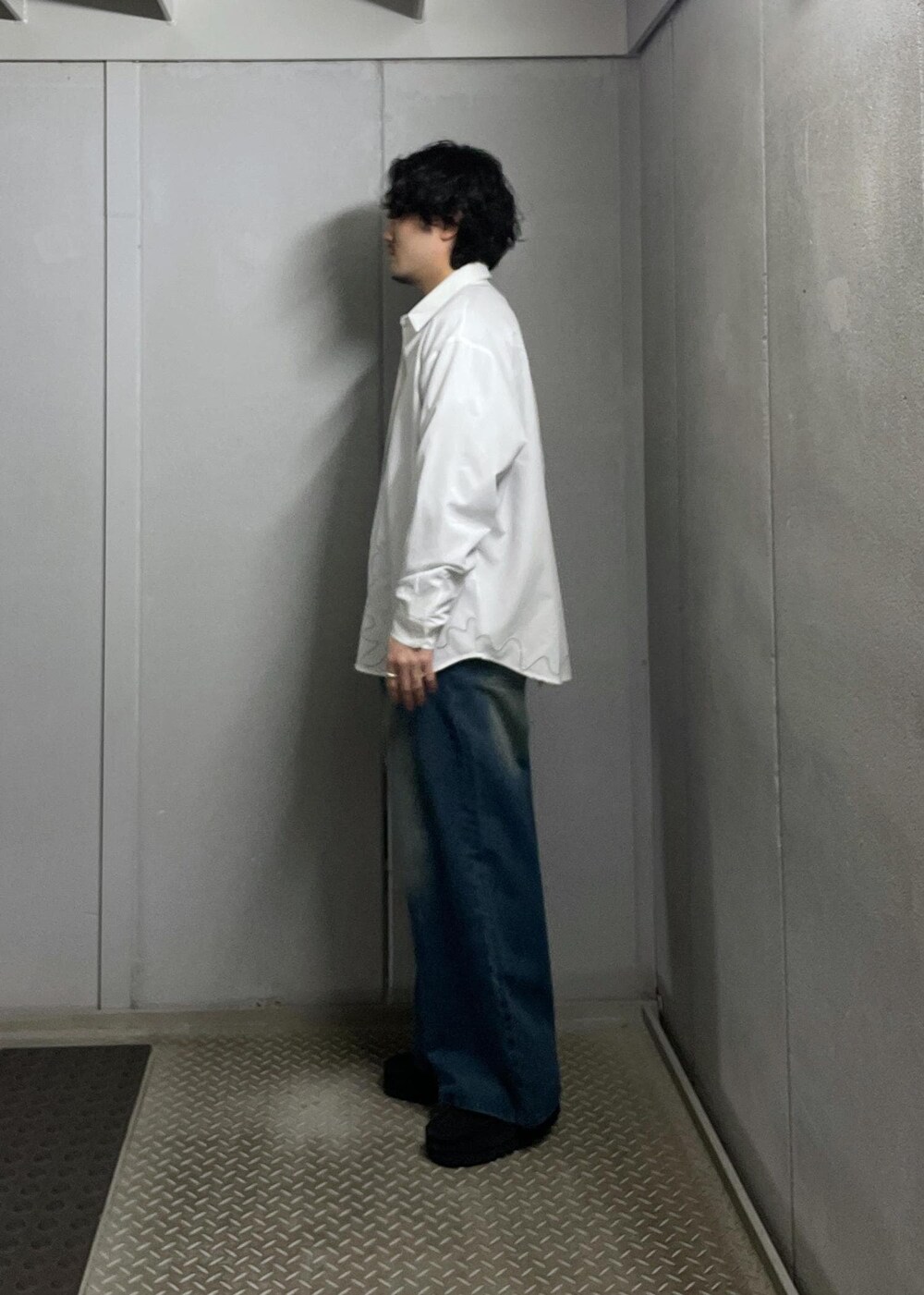 ブルー系のデニムパンツ、グレー系のニット/セーター、ホワイト系のシャツ/ブラウスを着用したメンズの冬コーディネートの4枚目の写真