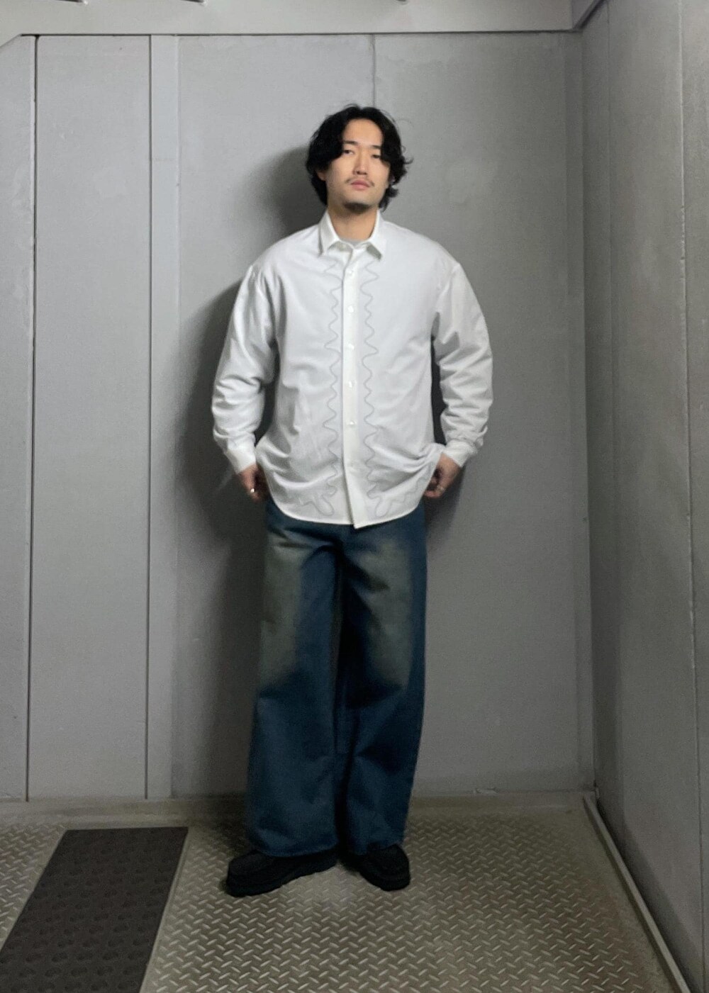 ブルー系のデニムパンツ、グレー系のニット/セーター、ホワイト系のシャツ/ブラウスを着用したメンズの冬コーディネートの5枚目の写真