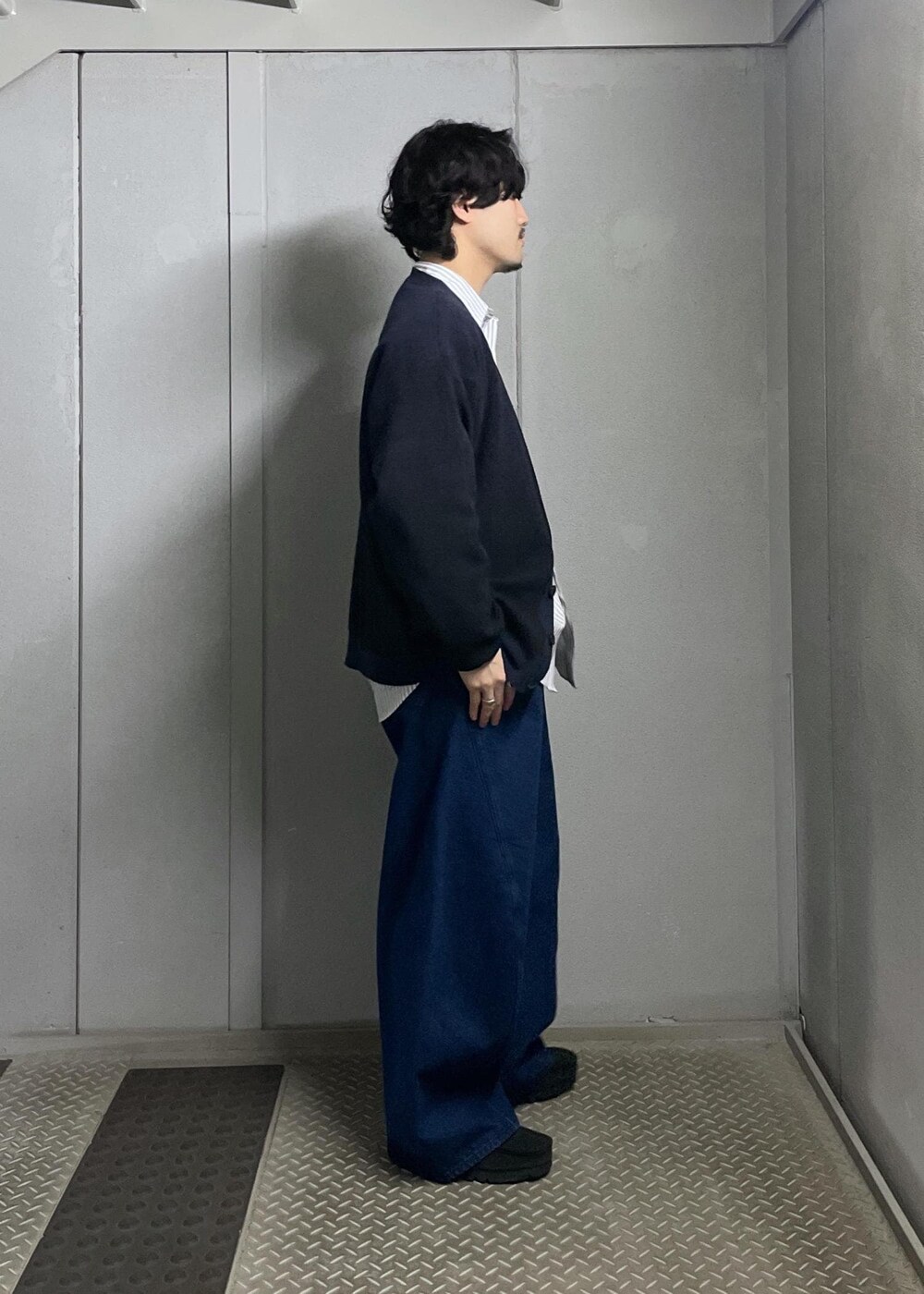 ブラック系のカーディガン/ボレロ、グレー系のシャツ/ブラウス、ブルー系のデニムパンツを着用したメンズの冬コーディネートの2枚目の写真