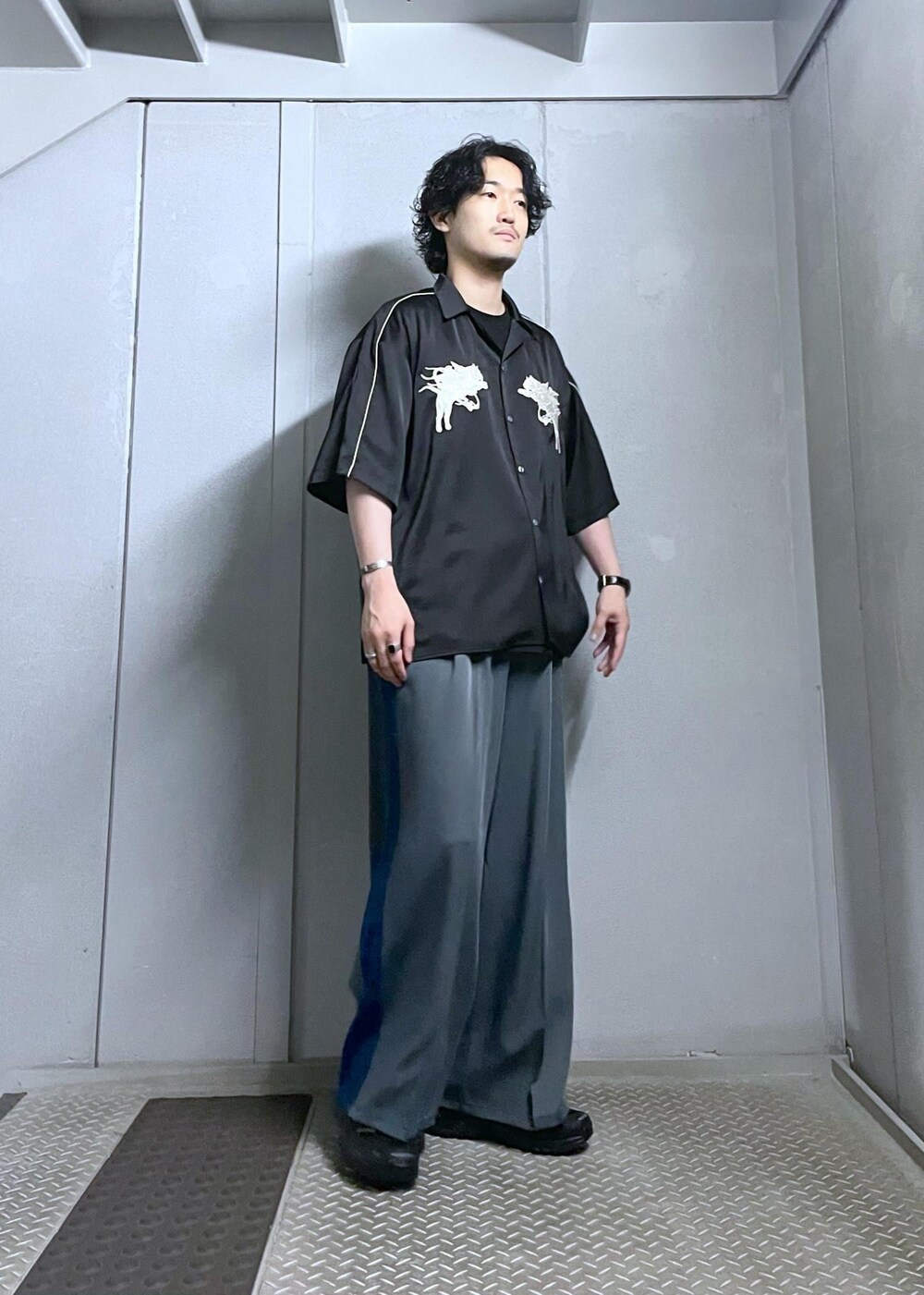 ブラック系のシャツ/ブラウス、グレー系のスラックスを着用したメンズの夏コーディネートの2枚目の写真