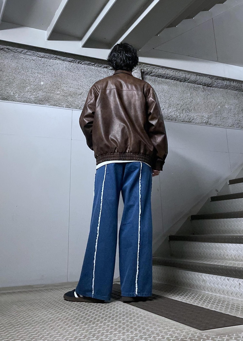 グレー系のスウェット、ブラウン系のブルゾンを着用したメンズの冬コーディネートの3枚目の写真