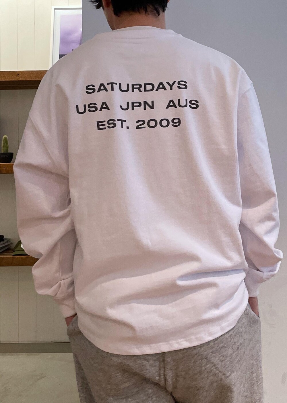 ホワイト系のTシャツ/カットソー、ブラック系のブルゾン、グレー系のその他パンツを着用したメンズの春コーディネートの7枚目の写真