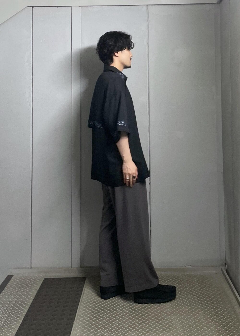 ブラック系のTシャツ/カットソー、ブラック系のシャツ/ブラウス、グレー系のスラックスを着用したメンズの夏コーディネートの3枚目の写真