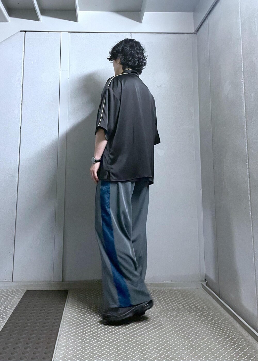 ブラック系のシャツ/ブラウス、グレー系のスラックスを着用したメンズの夏コーディネートの4枚目の写真