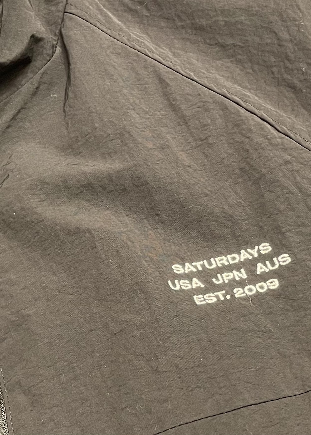 ホワイト系のTシャツ/カットソー、ブラック系のブルゾン、グレー系のその他パンツを着用したメンズの春コーディネートの9枚目の写真