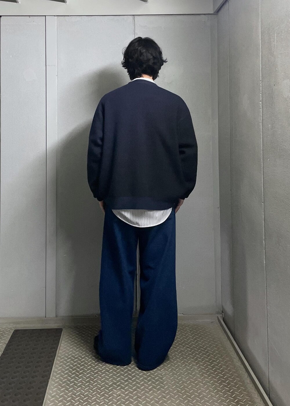 ブラック系のカーディガン/ボレロ、グレー系のシャツ/ブラウス、ブルー系のデニムパンツを着用したメンズの冬コーディネートの3枚目の写真