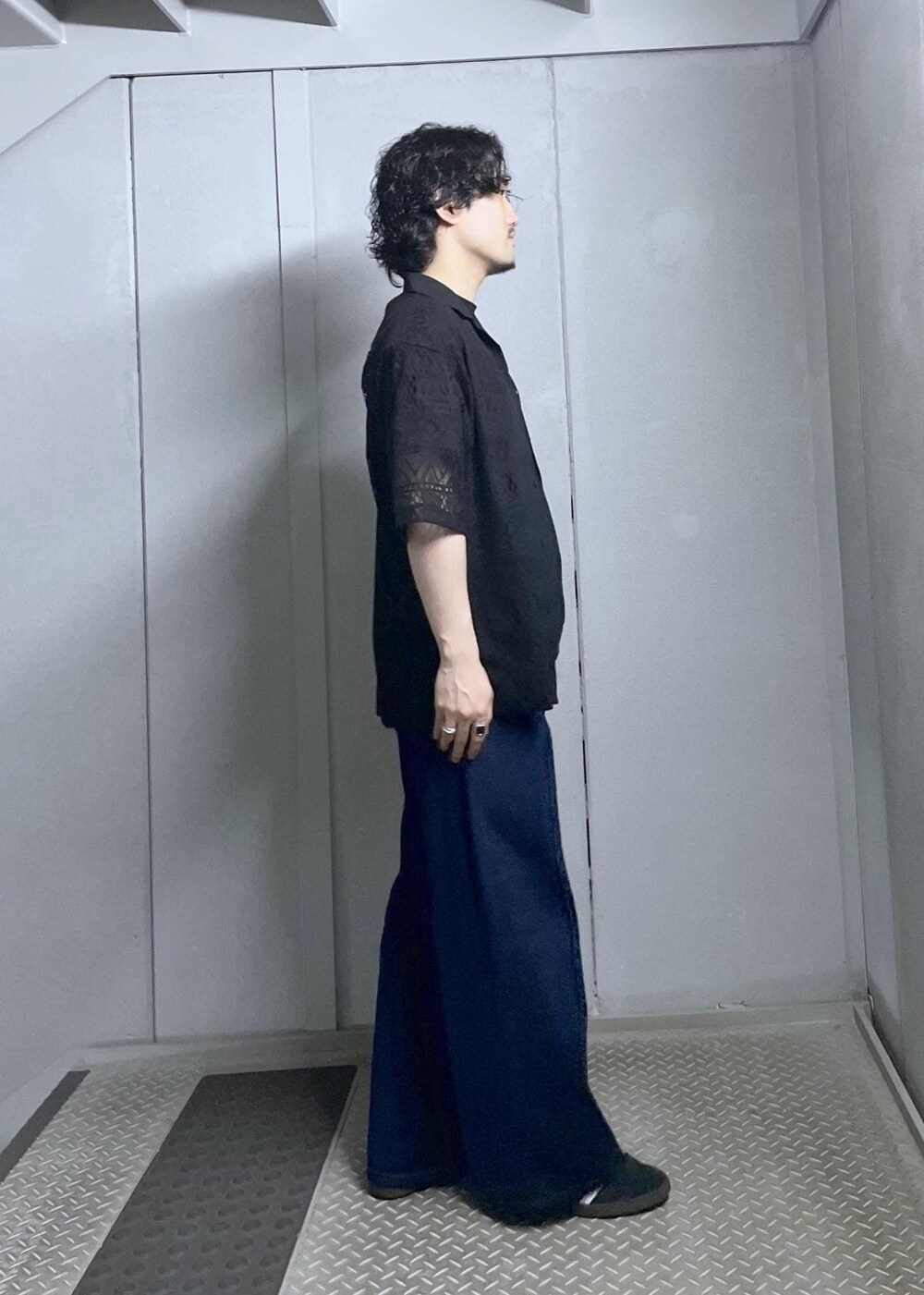 ブルー系のデニムパンツ、ブラック系のシャツ/ブラウスを着用したメンズの夏コーディネートの2枚目の写真