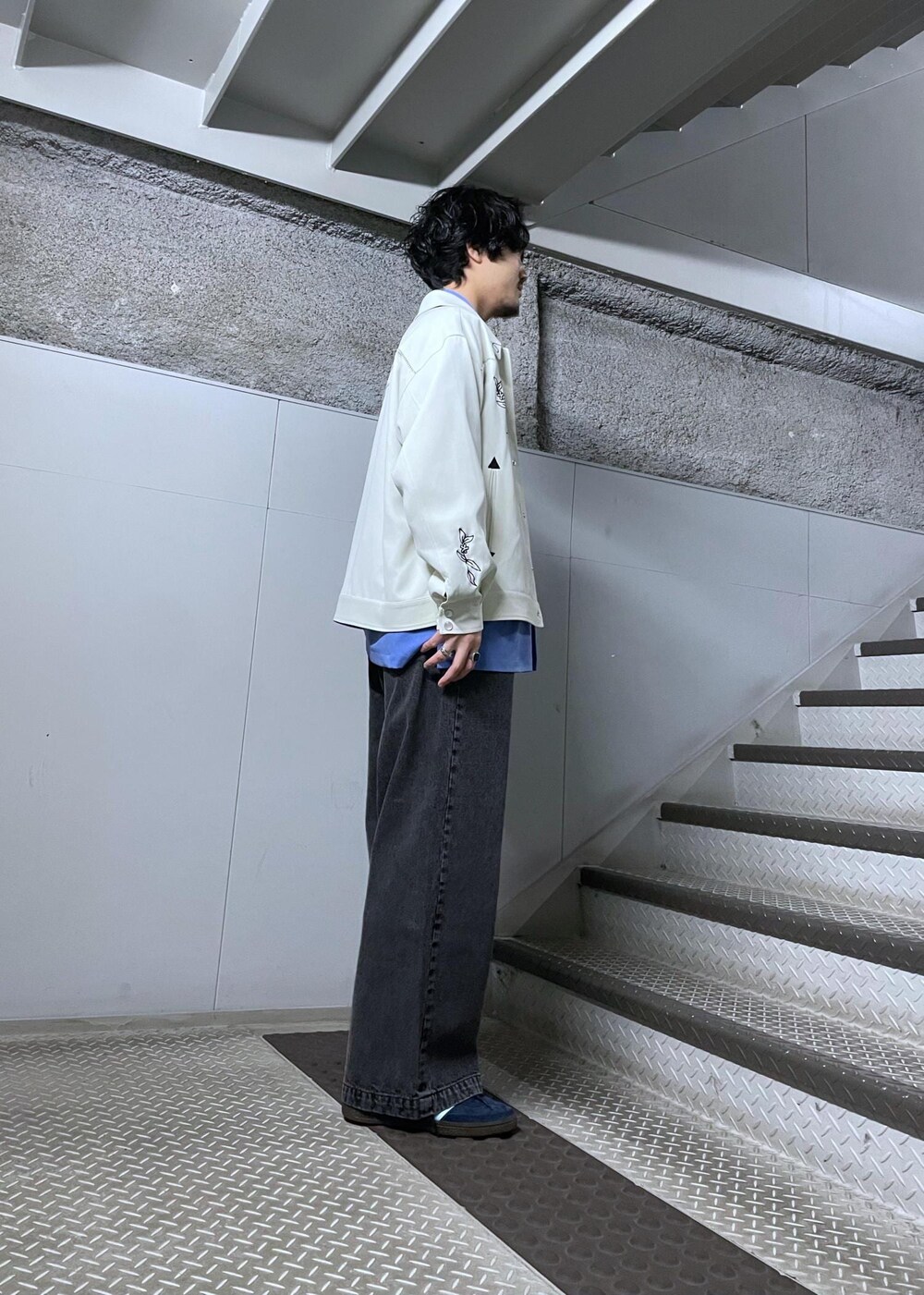 ホワイト系のブルゾン、ブラック系のデニムパンツ、ブルー系のシャツ/ブラウスを着用したメンズの冬コーディネートの2枚目の写真