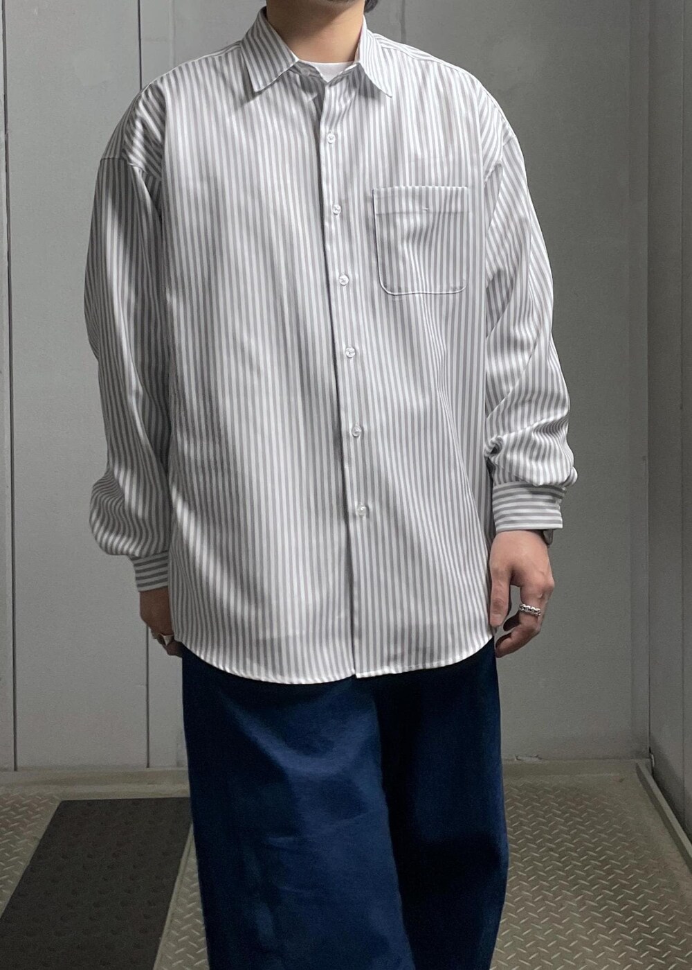 ブラック系のカーディガン/ボレロ、グレー系のシャツ/ブラウス、ブルー系のデニムパンツを着用したメンズの冬コーディネートの8枚目の写真