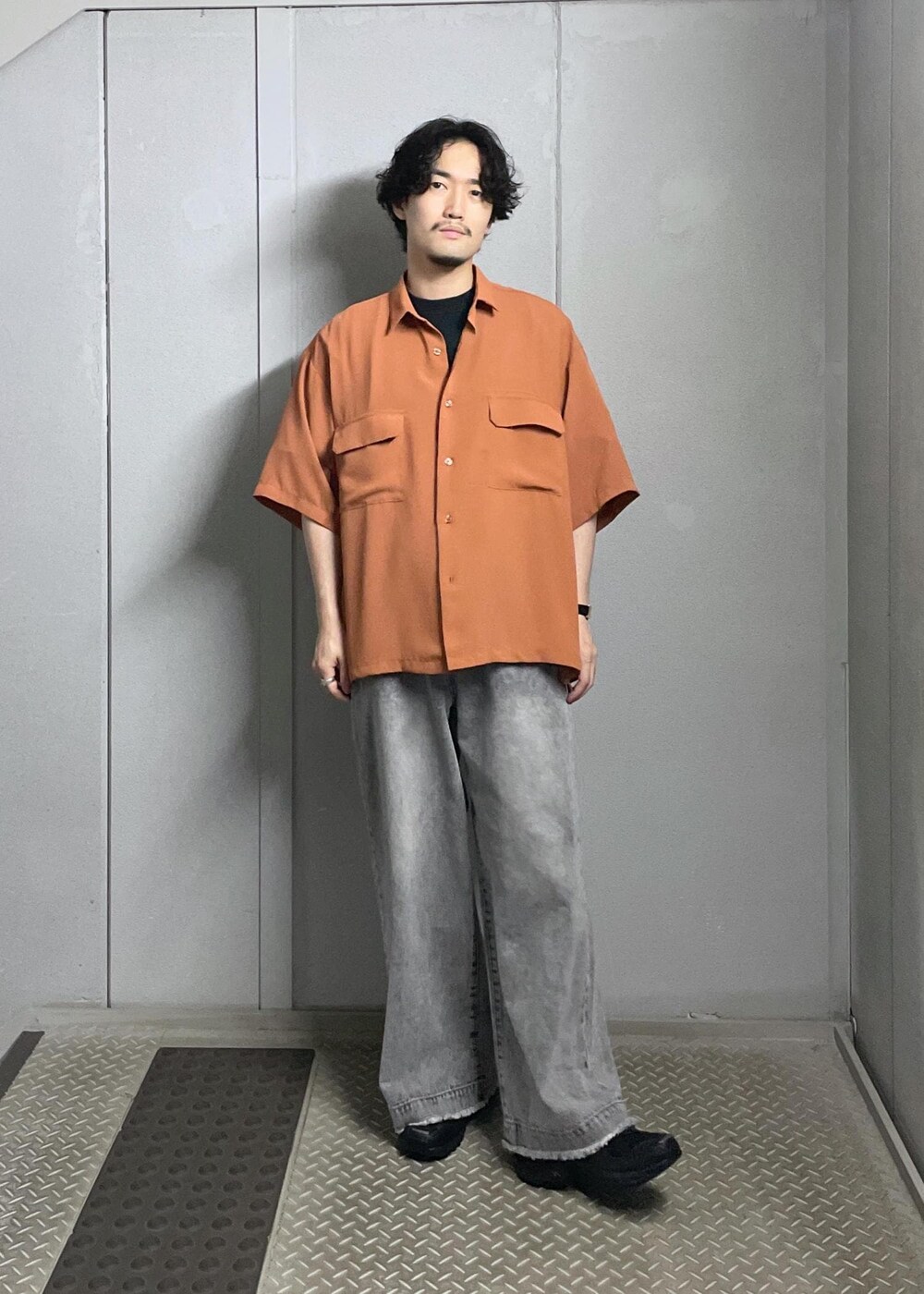 グレー系のデニムパンツ、オレンジ系のシャツ/ブラウスを着用したメンズの夏コーディネートの6枚目の写真