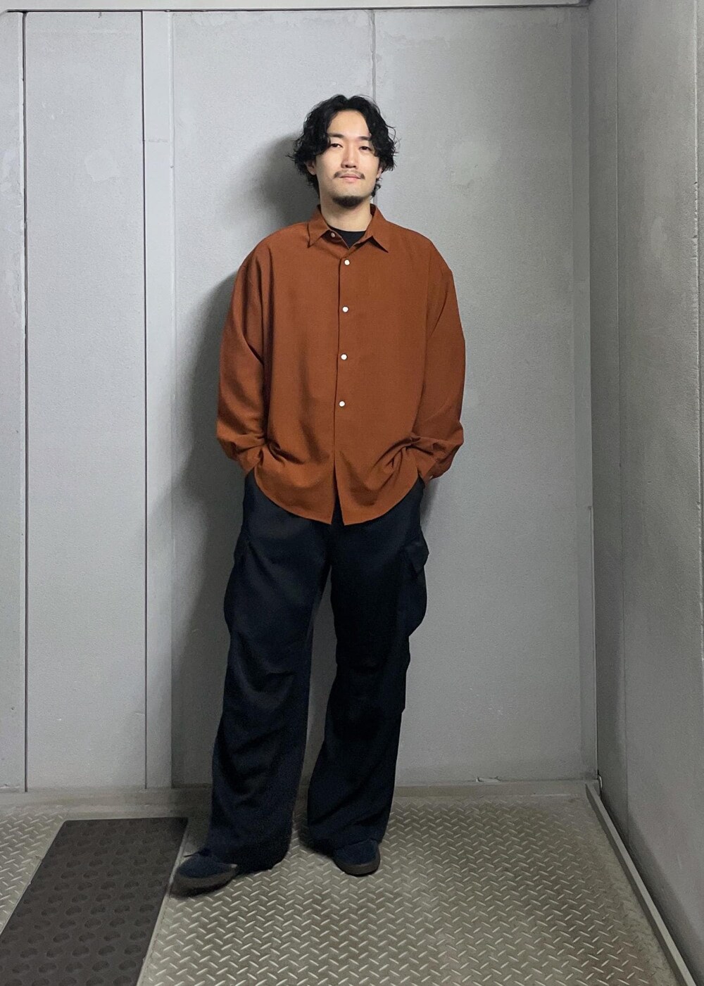 オレンジ系のシャツ/ブラウス、ブラック系のカーゴパンツを着用したメンズの夏コーディネートの2枚目の写真