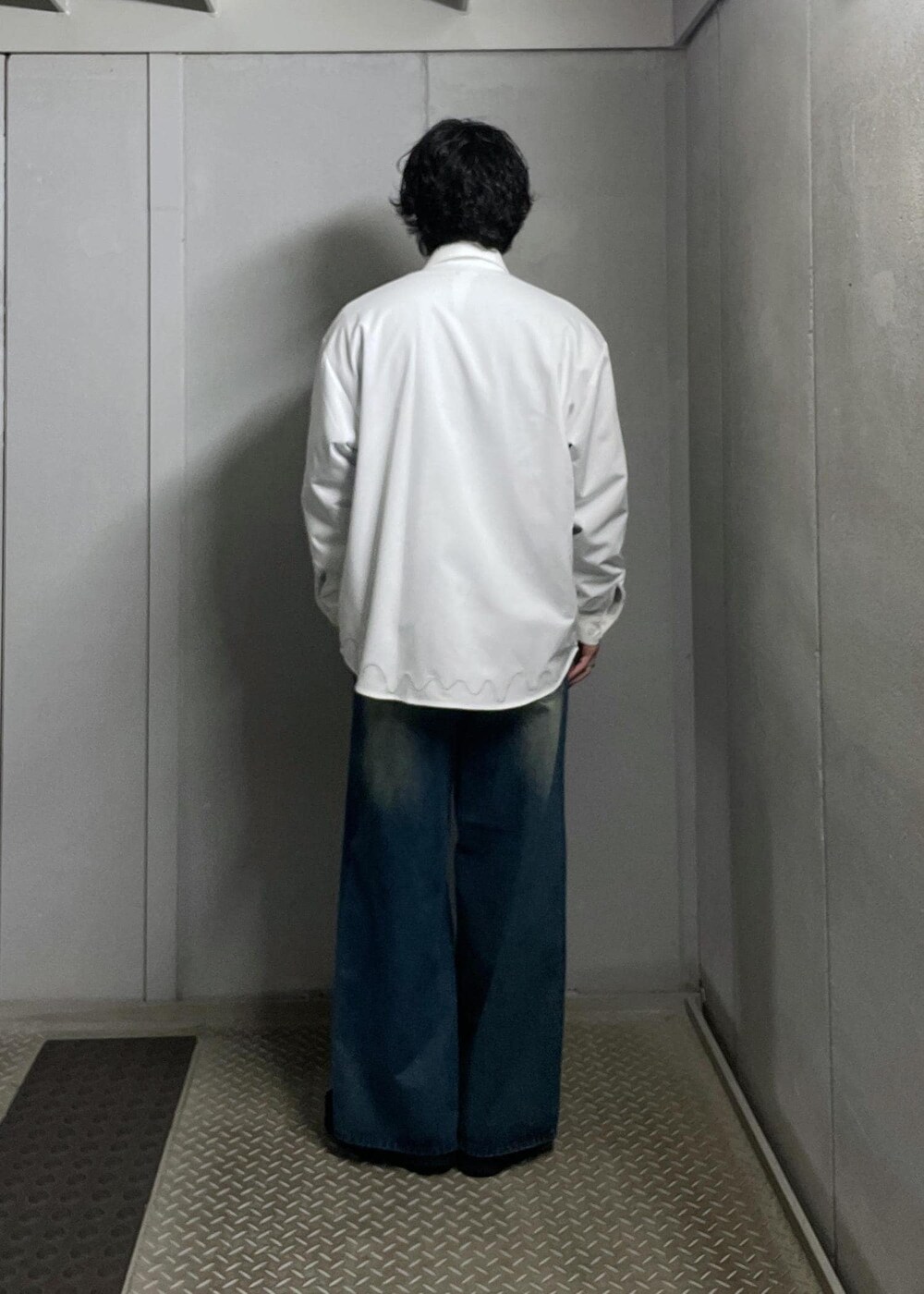 ブルー系のデニムパンツ、グレー系のニット/セーター、ホワイト系のシャツ/ブラウスを着用したメンズの冬コーディネートの3枚目の写真