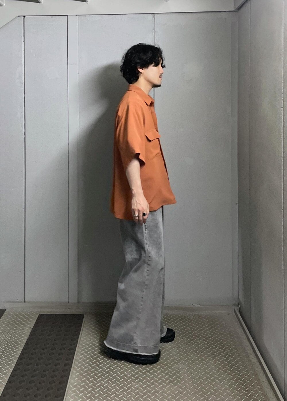 グレー系のデニムパンツ、オレンジ系のシャツ/ブラウスを着用したメンズの夏コーディネートの3枚目の写真