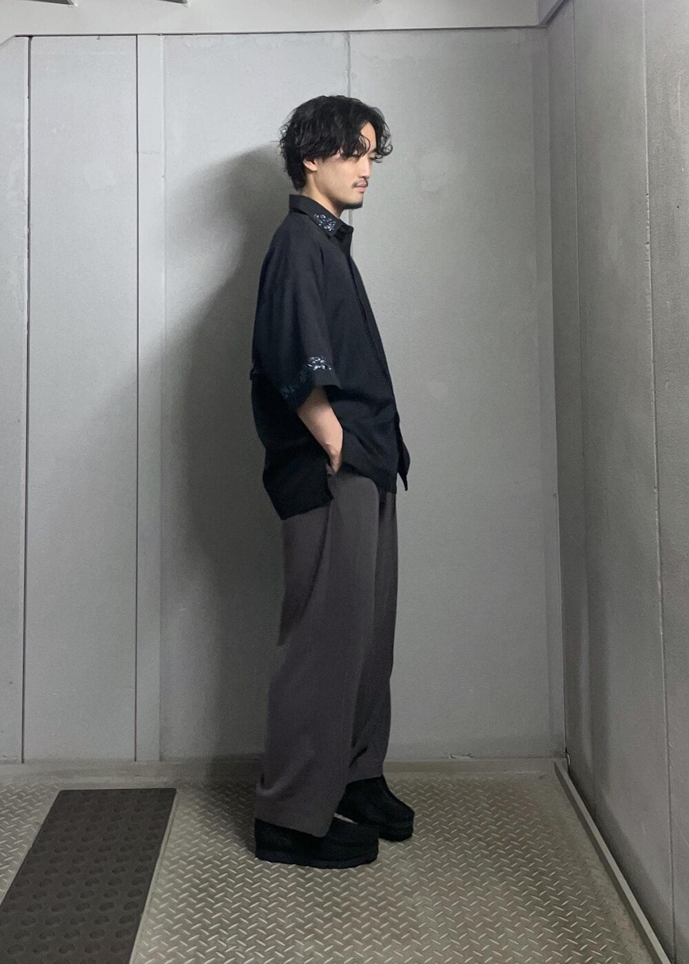 ブラック系のTシャツ/カットソー、ブラック系のシャツ/ブラウス、グレー系のスラックスを着用したメンズの夏コーディネートの4枚目の写真