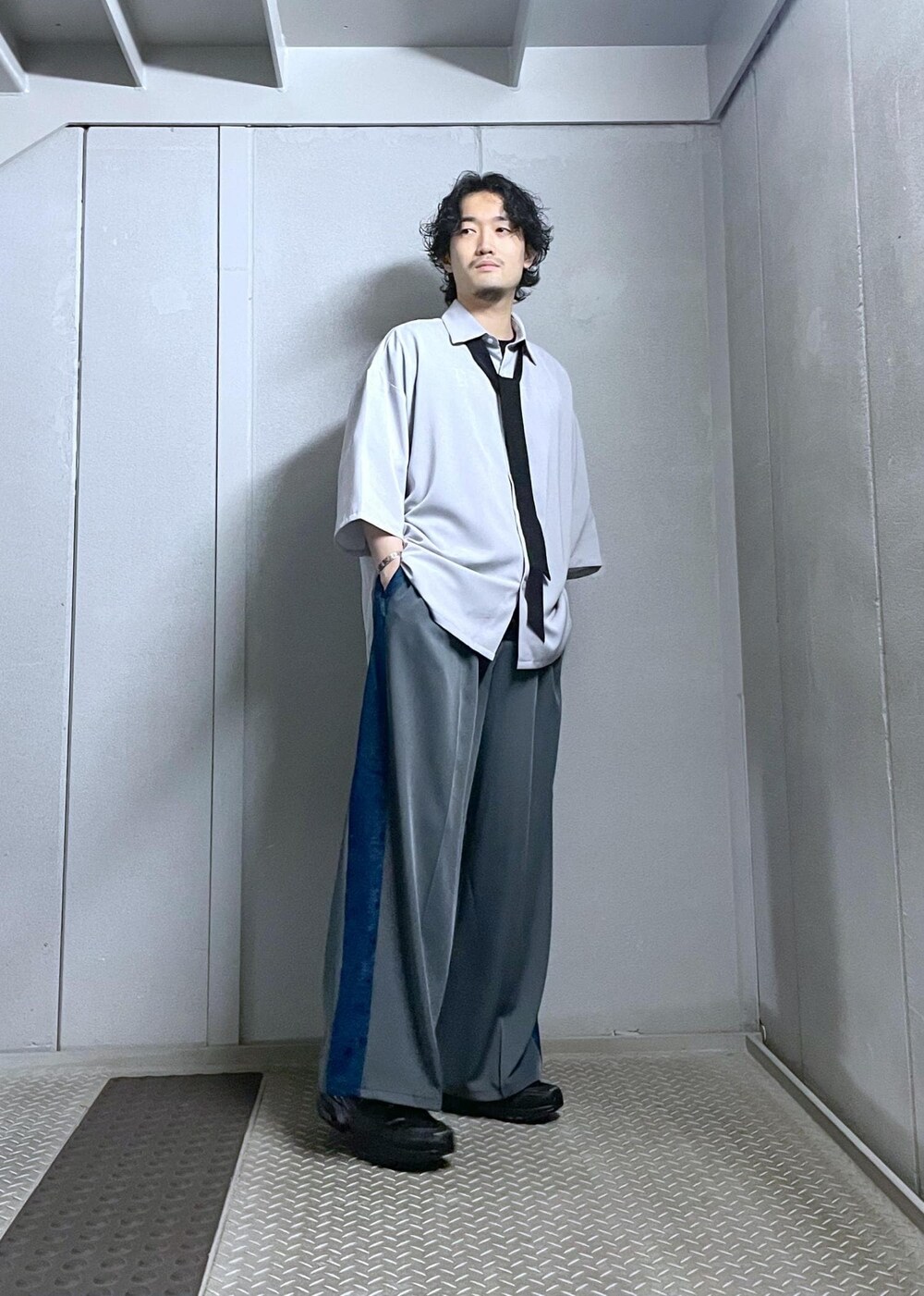 グレー系のシャツ/ブラウス、グレー系のスラックスを着用したメンズの夏コーディネートの2枚目の写真