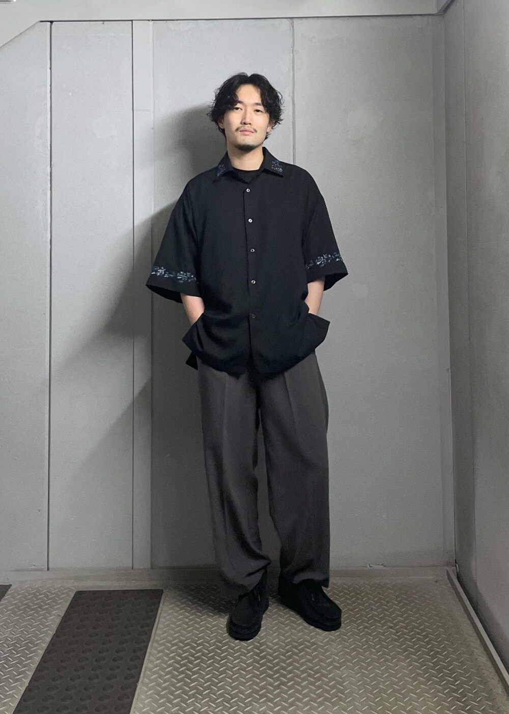 ブラック系のTシャツ/カットソー、ブラック系のシャツ/ブラウス、グレー系のスラックスを着用したメンズの夏コーディネートの2枚目の写真