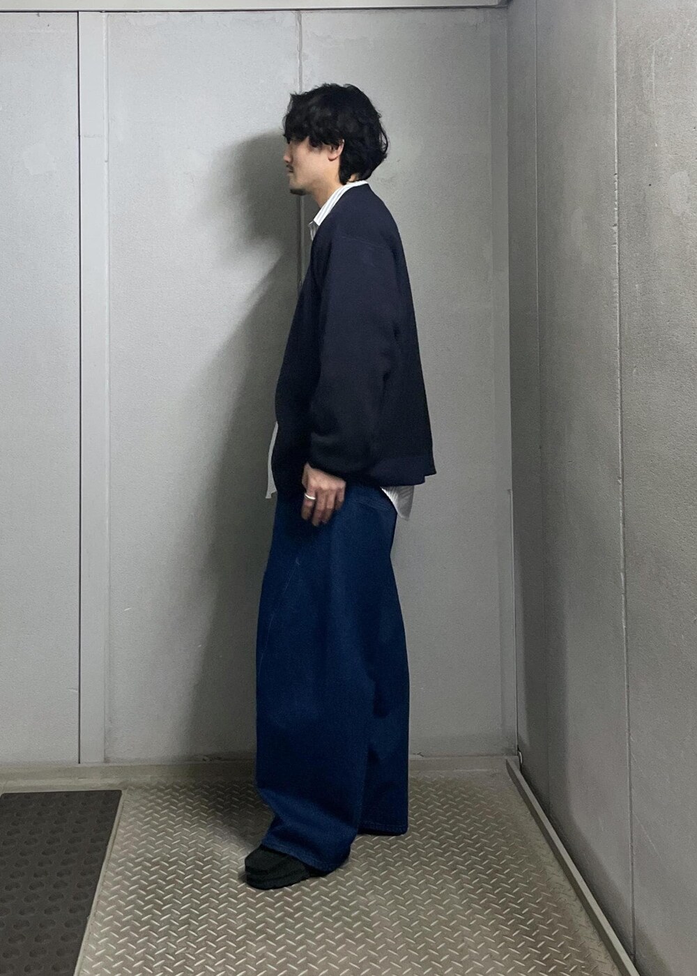 ブラック系のカーディガン/ボレロ、グレー系のシャツ/ブラウス、ブルー系のデニムパンツを着用したメンズの冬コーディネートの4枚目の写真