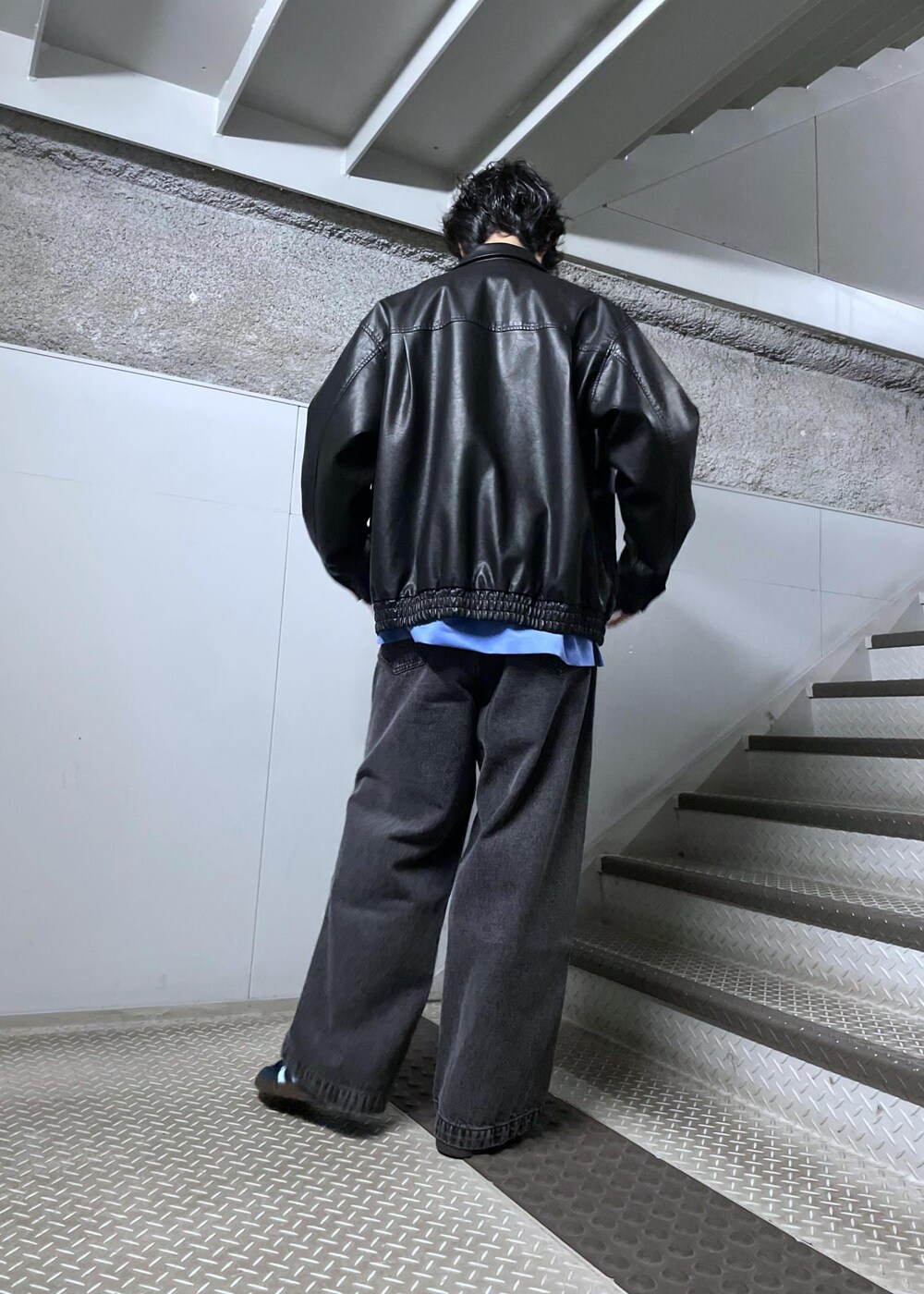 ブラック系のデニムパンツ、ブラック系のブルゾン、ブルー系のシャツ/ブラウスを着用したメンズの冬コーディネートの3枚目の写真