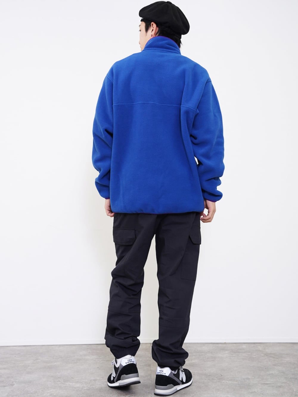 ブルー系のノーカラージャケット、ブラック系のカーゴパンツ、ブラック系のスニーカーを着用したメンズの冬コーディネートの3枚目の写真