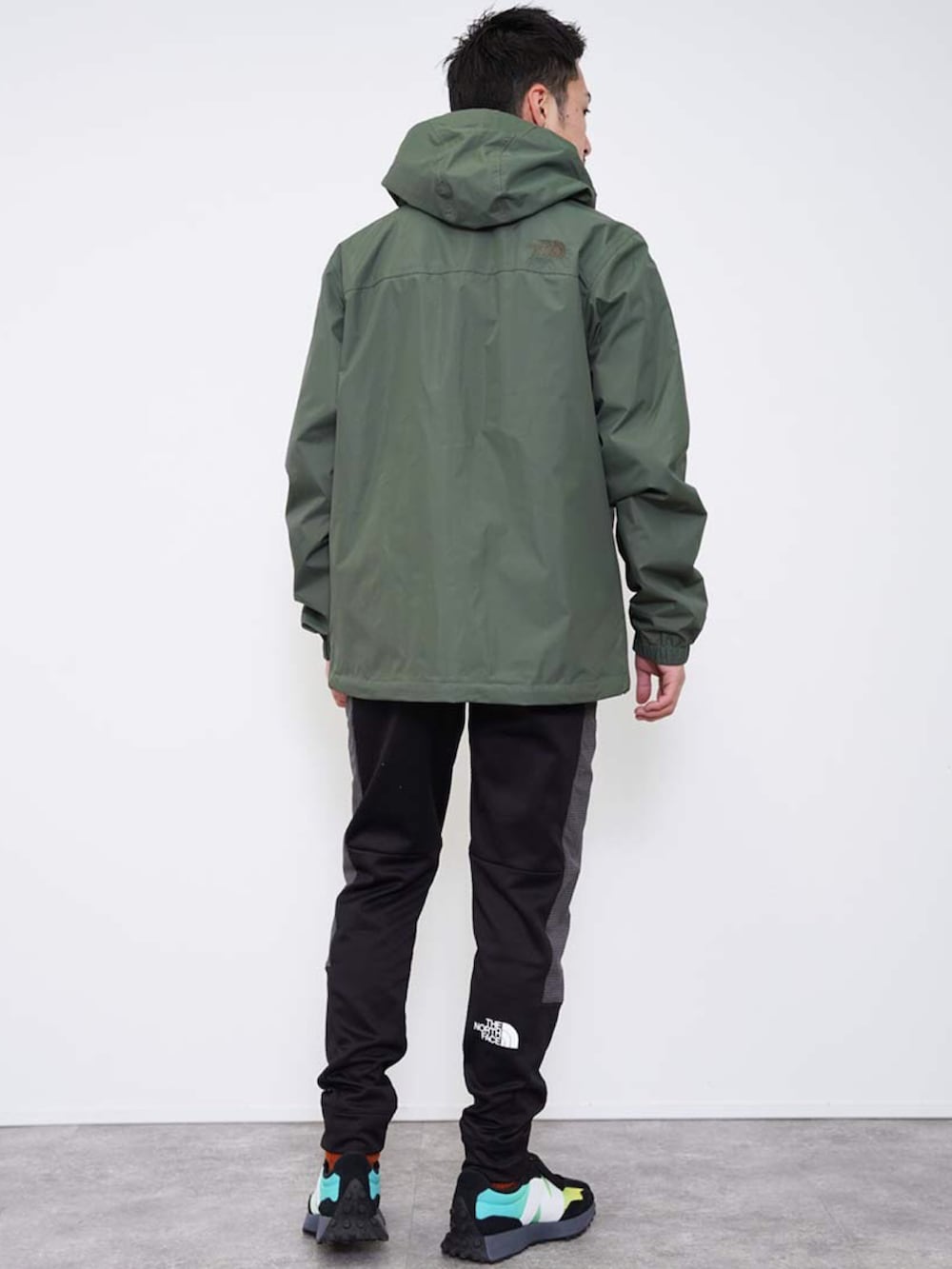 グリーン系のナイロンジャケット、ブラック系のその他パンツ、ホワイト系のその他を着用したメンズの冬コーディネートの4枚目の写真