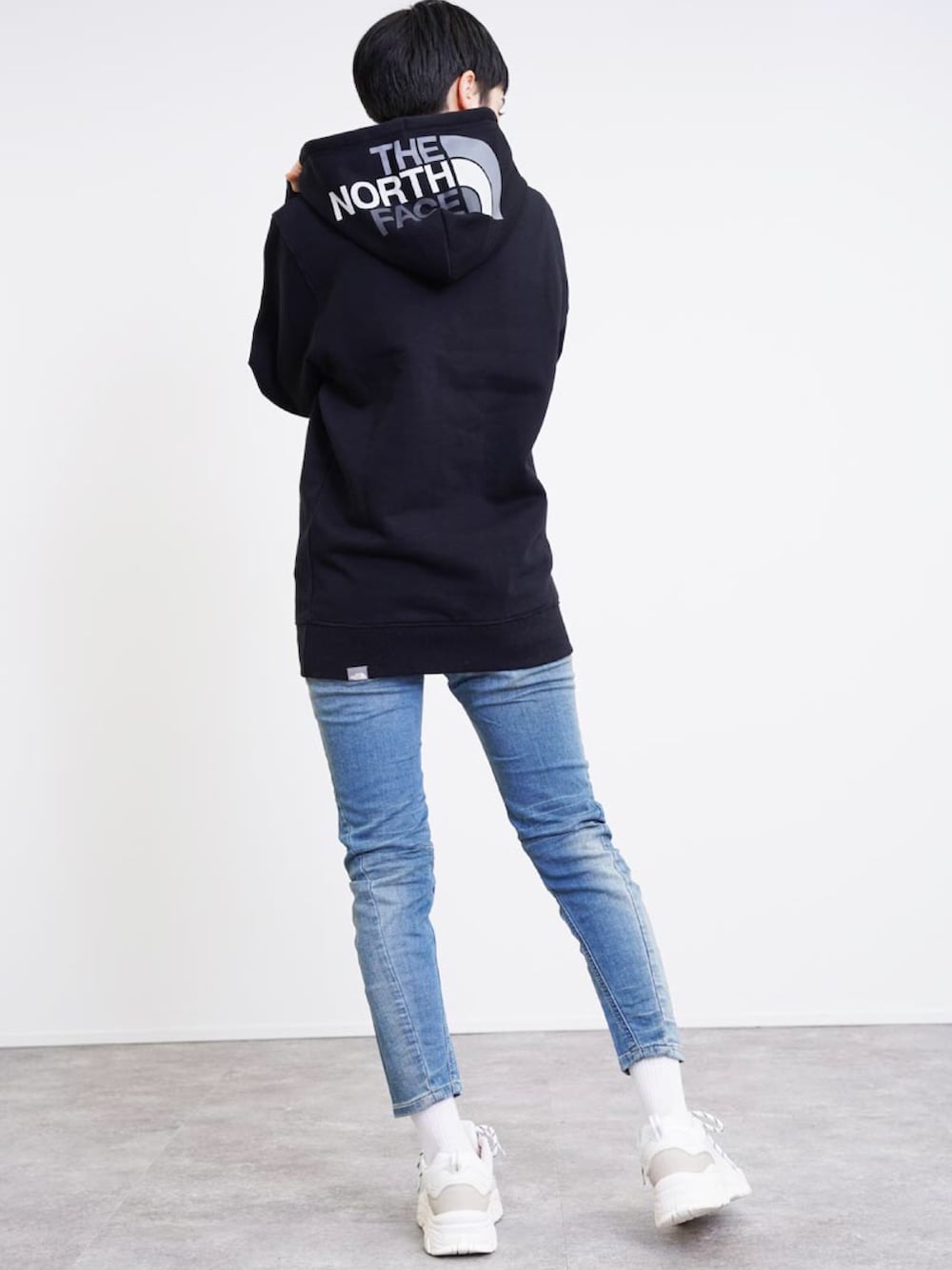 ブラック系のパーカー、ホワイト系のスニーカー、ホワイト系のその他を着用したレディースの秋コーディネートの2枚目の写真