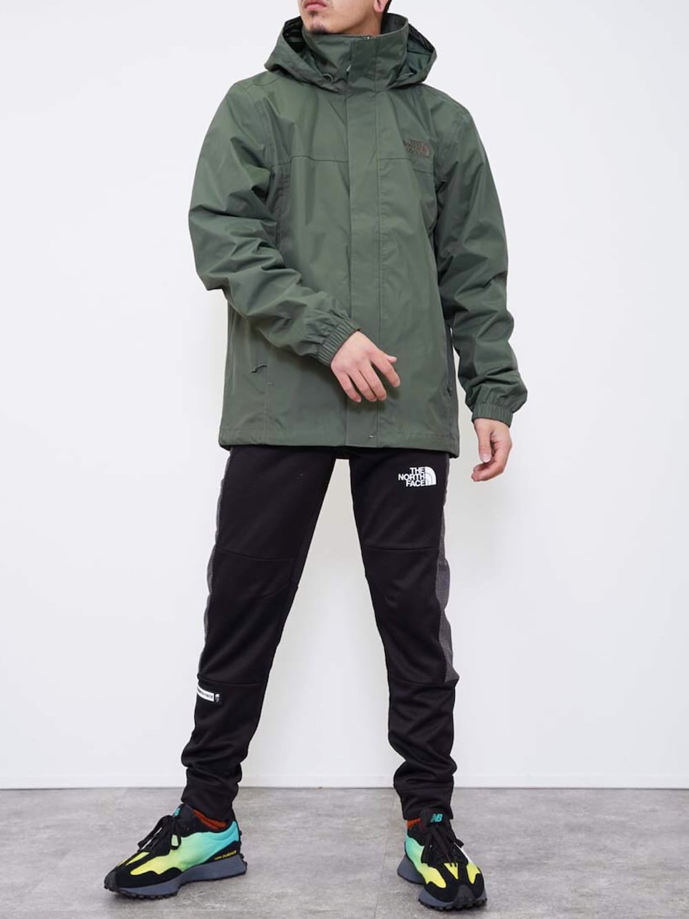 グリーン系のナイロンジャケット、ブラック系のその他パンツ、ホワイト系のその他を着用したメンズの冬コーディネートの2枚目の写真