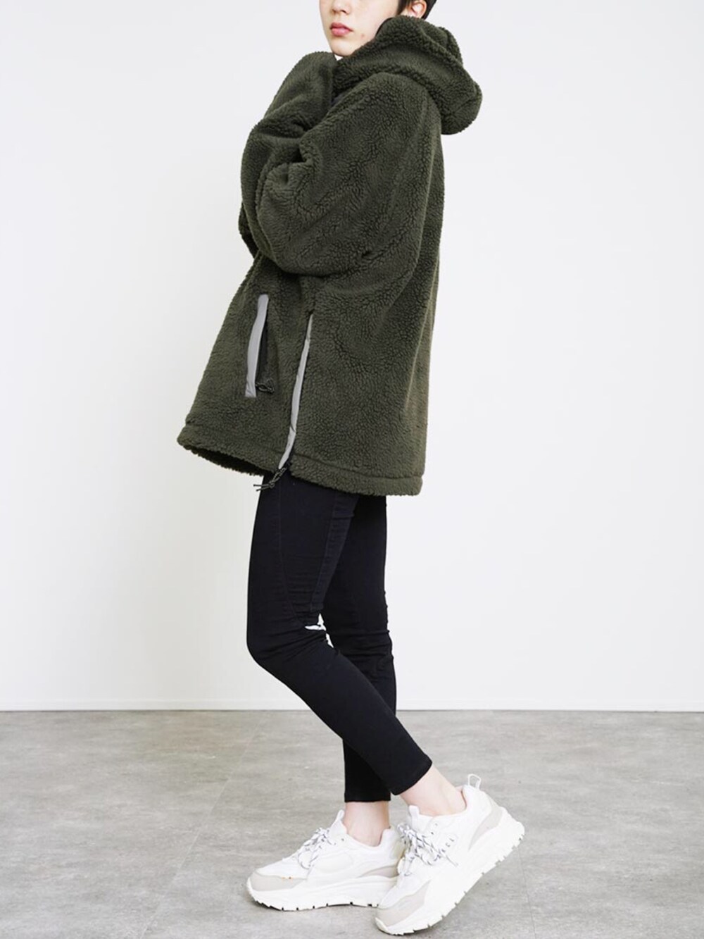 グリーン系のパーカー、ホワイト系のスニーカー、ホワイト系のその他を着用したレディースの冬コーディネートの2枚目の写真