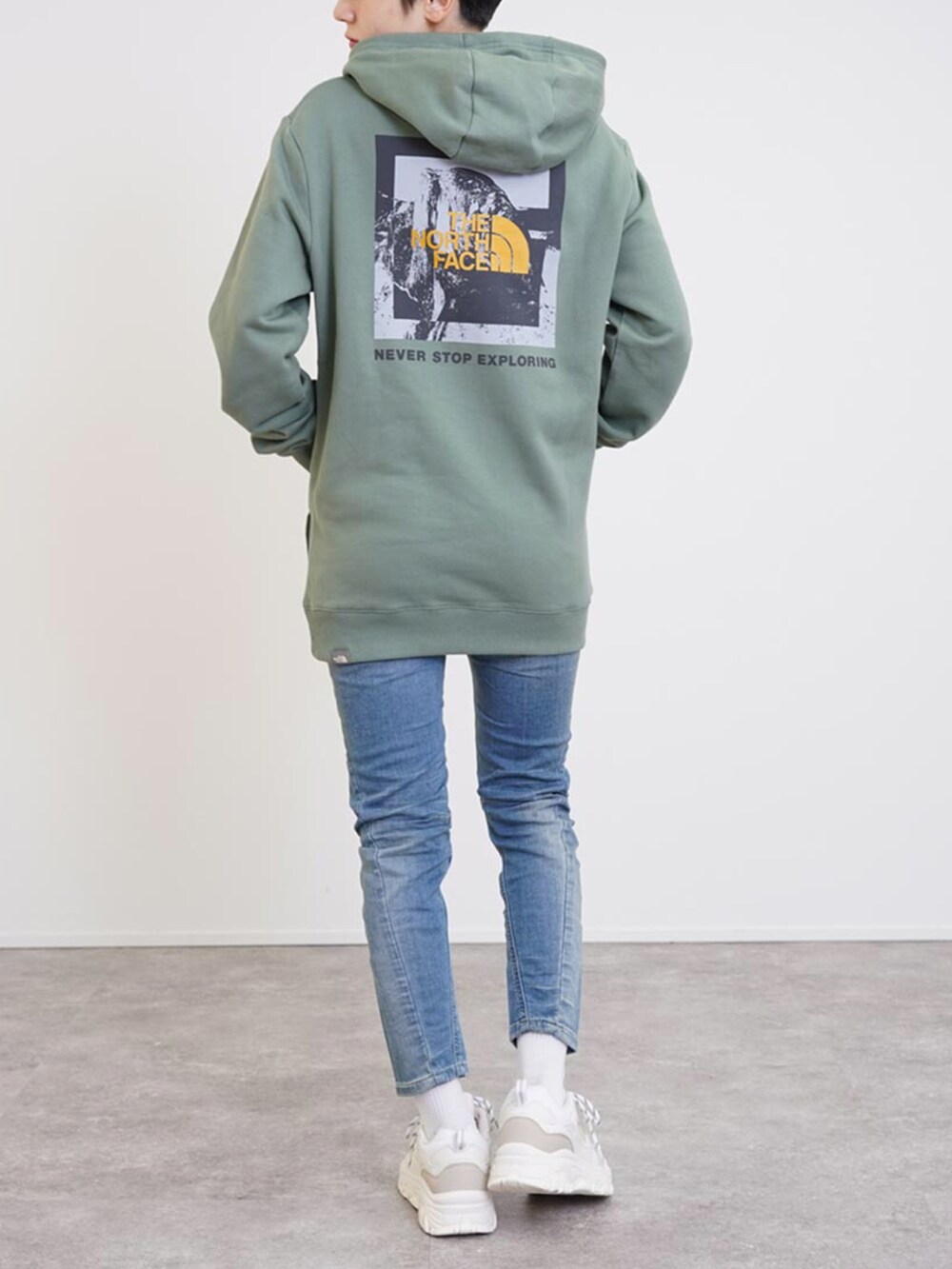 グリーン系のパーカー、ホワイト系のスニーカー、ホワイト系のその他を着用したレディースの秋コーディネートの2枚目の写真