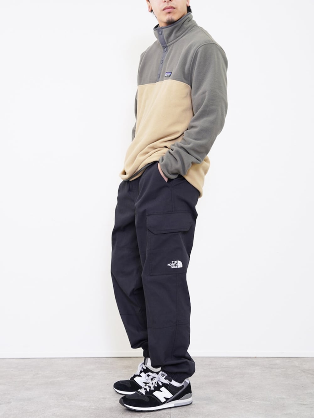 ブラック系のカーゴパンツ、グリーン系のノーカラージャケット、ブラック系のスニーカーを着用したメンズの冬コーディネートの2枚目の写真