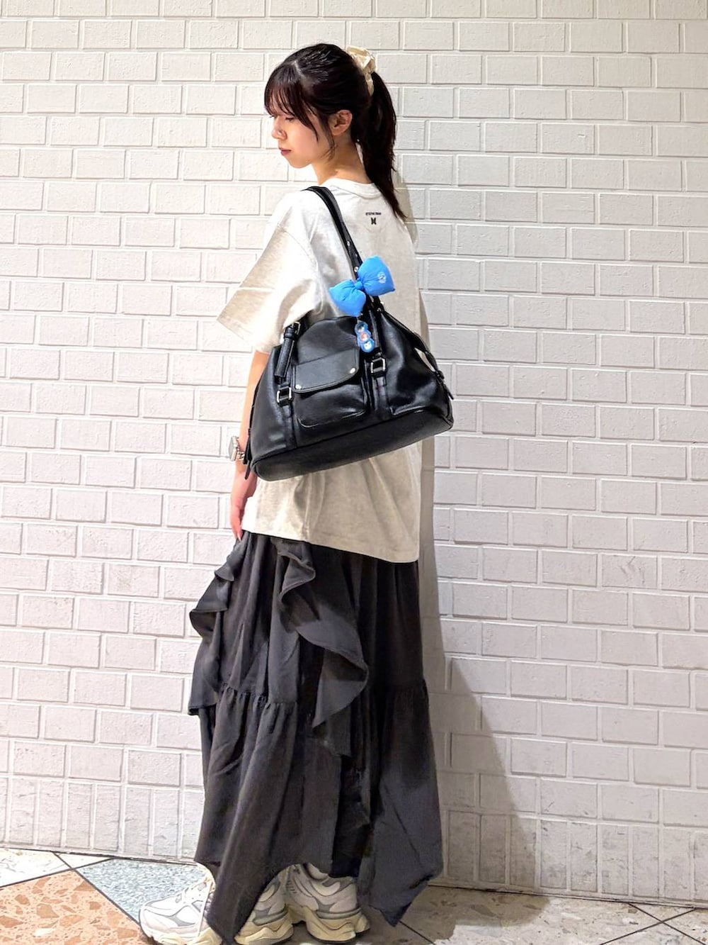 グレー系のスカート、ブラック系のボストンバッグ、ホワイト系のTシャツ/カットソーを着用したレディースの春コーディネートの8枚目の写真