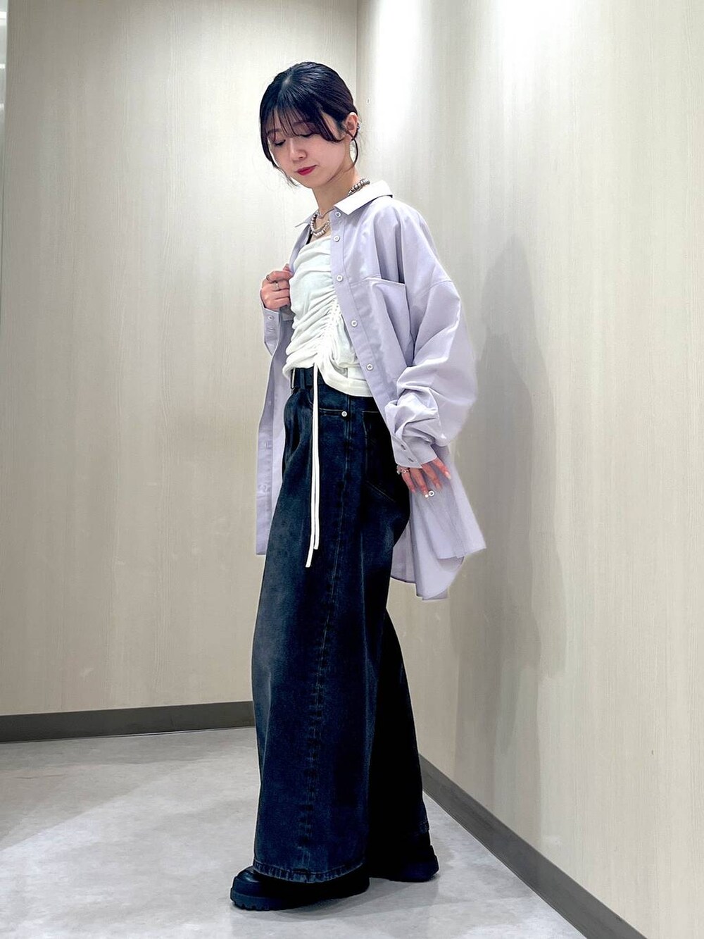 ブラック系のデニムパンツ、パープル系のシャツ/ブラウス、ホワイト系のTシャツ/カットソーを着用したレディースの春コーディネートの2枚目の写真