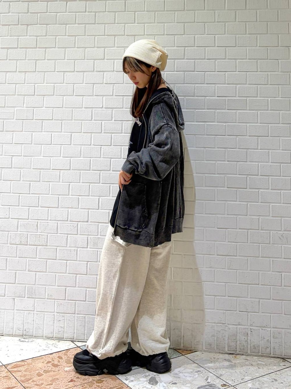 ブラック系のブーツ、グレー系のパーカー、ブラック系のTシャツ/カットソーを着用したレディースの春コーディネートの2枚目の写真