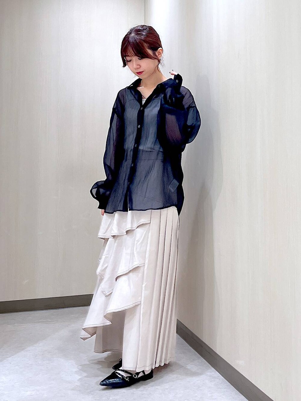 ブラック系のパンプス、ブラック系のシャツ/ブラウス、グレー系のスカートを着用したレディースの秋コーディネートの2枚目の写真