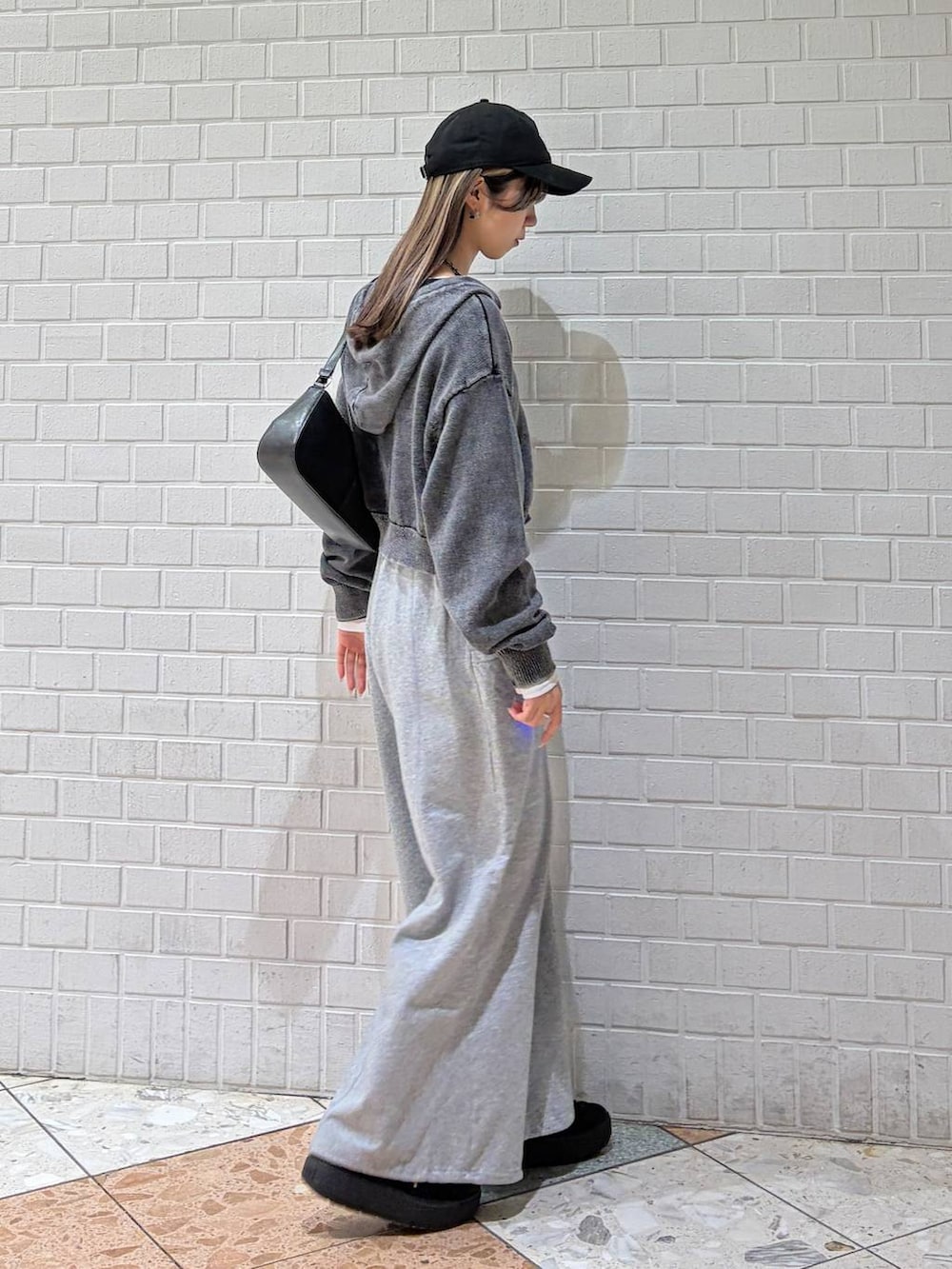 ブラック系のハンドバッグ、グレー系のスウェットパンツ、グレー系のパーカーを着用したレディースの冬コーディネートの5枚目の写真