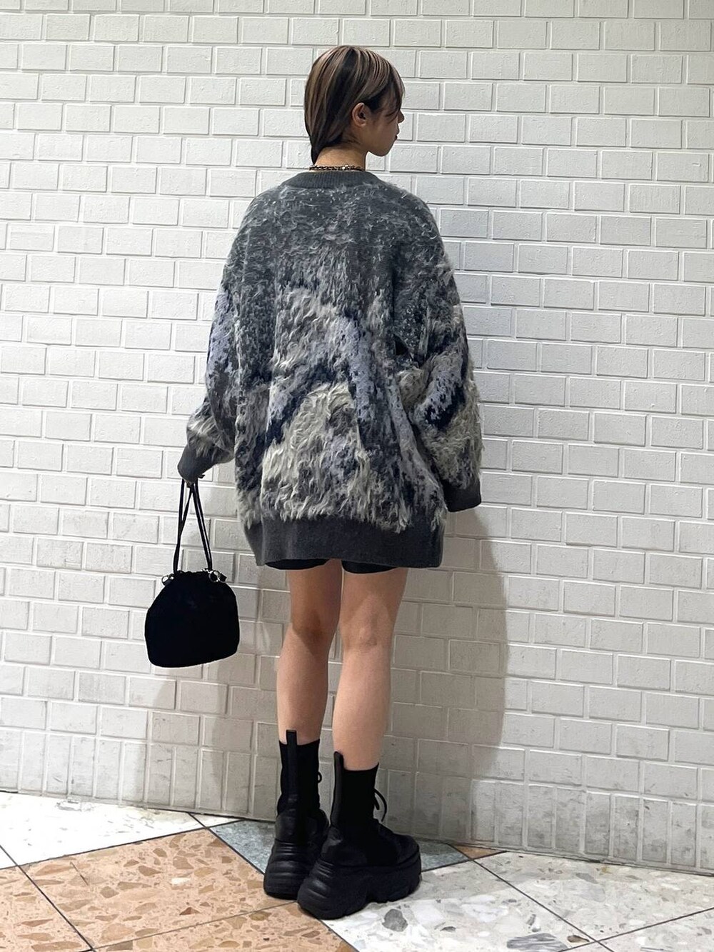 ブラック系のブーツ、ホワイト系のカーディガン/ボレロ、ホワイト系のニット/セーターを着用したレディースの冬コーディネートの3枚目の写真