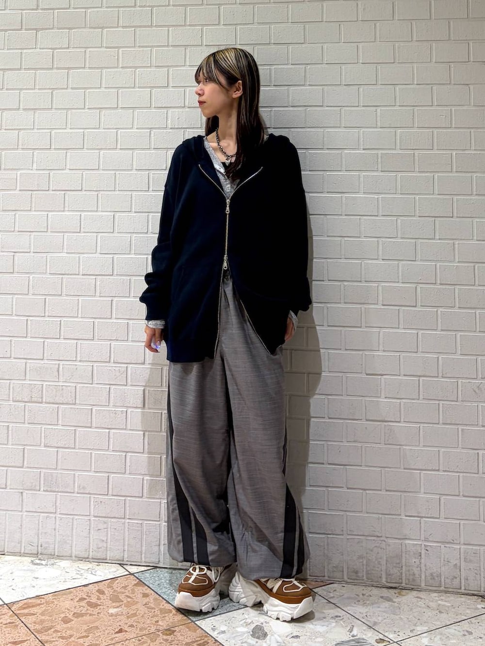 ベージュ系のスニーカー、ブルー系のパーカー、グレー系のその他パンツを着用したレディースの春コーディネートの4枚目の写真