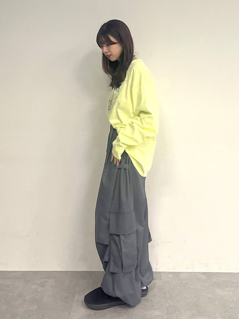 グレー系のカーゴパンツ、イエロー系のTシャツ/カットソー、ブラック系のネックレスを着用したレディースの冬コーディネートの3枚目の写真