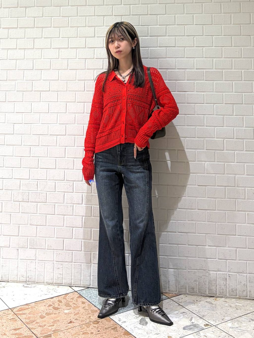 ブルー系のデニムパンツ、ブラウン系のハンドバッグ、ブラウン系のサンダルを着用したレディースの春コーディネートの7枚目の写真