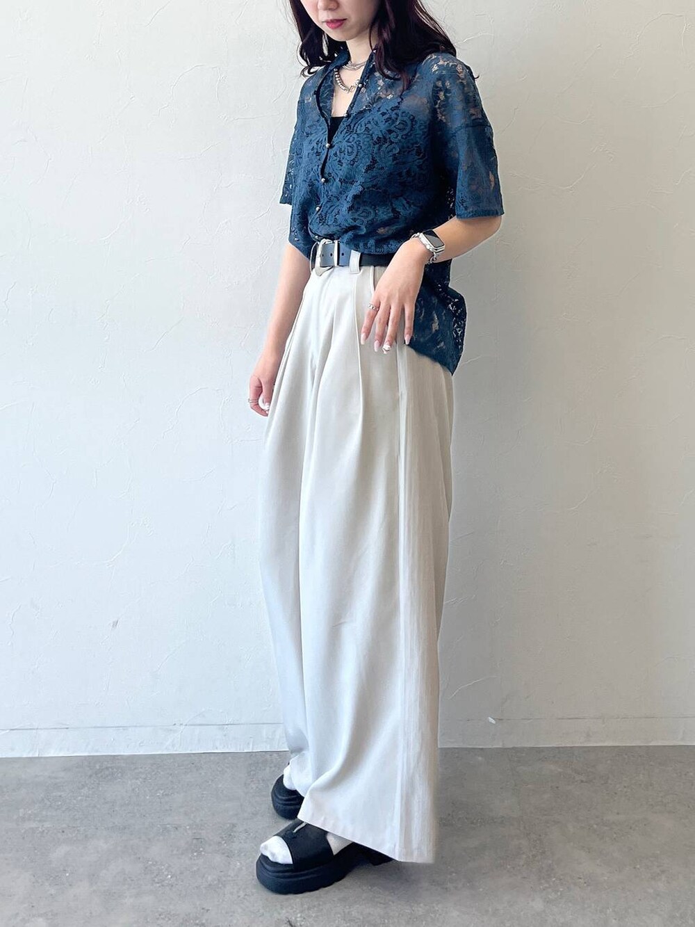 グリーン系のシャツ/ブラウス、ベージュ系のスラックス、ブラック系のベルトを着用したレディースの春コーディネートの5枚目の写真