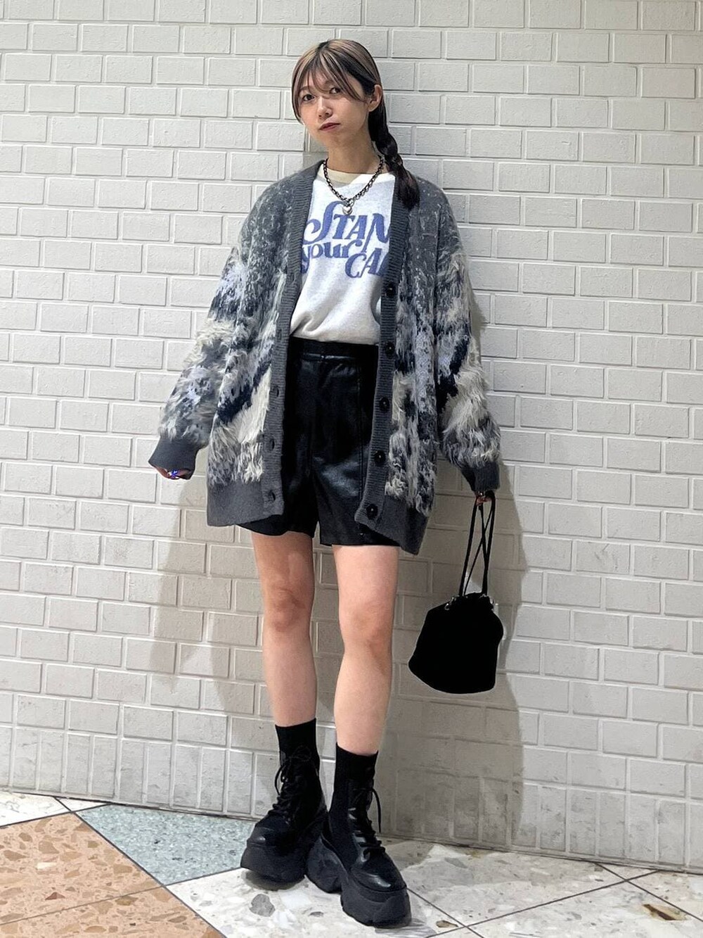 ブラック系のブーツ、ホワイト系のカーディガン/ボレロ、ホワイト系のニット/セーターを着用したレディースの冬コーディネートの4枚目の写真