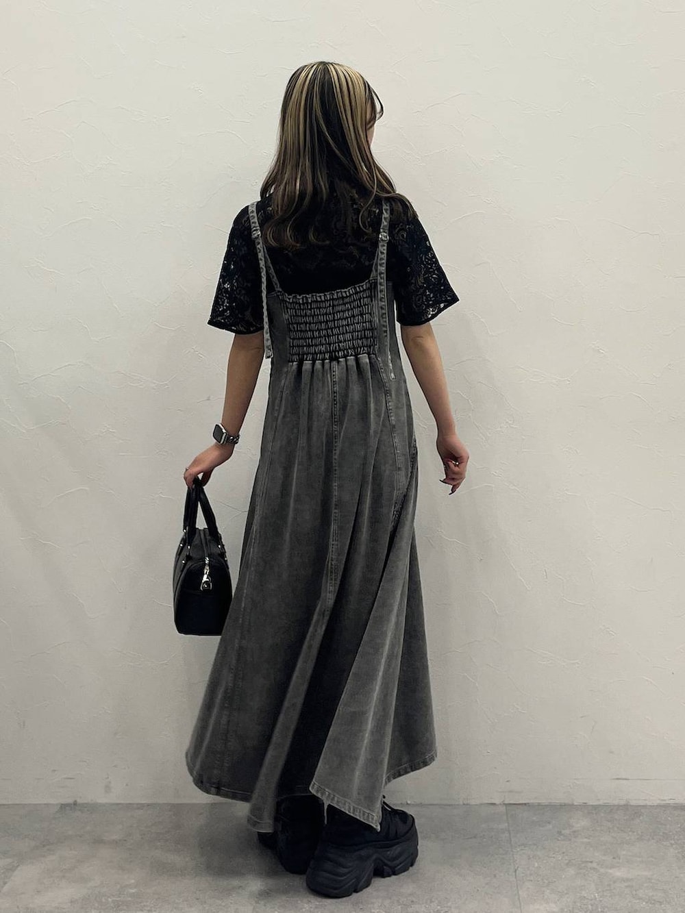 ブラック系のスニーカー、ブラック系のシャツ/ブラウス、ブラック系のボストンバッグを着用したレディースの冬コーディネートの2枚目の写真