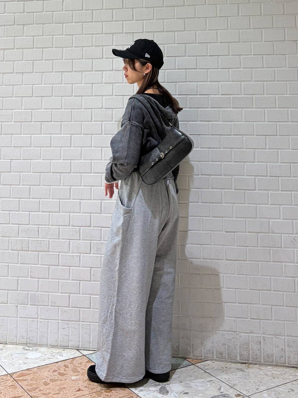 ブラック系のハンドバッグ、グレー系のスウェットパンツ、グレー系のパーカーを着用したレディースの冬コーディネートの6枚目の写真