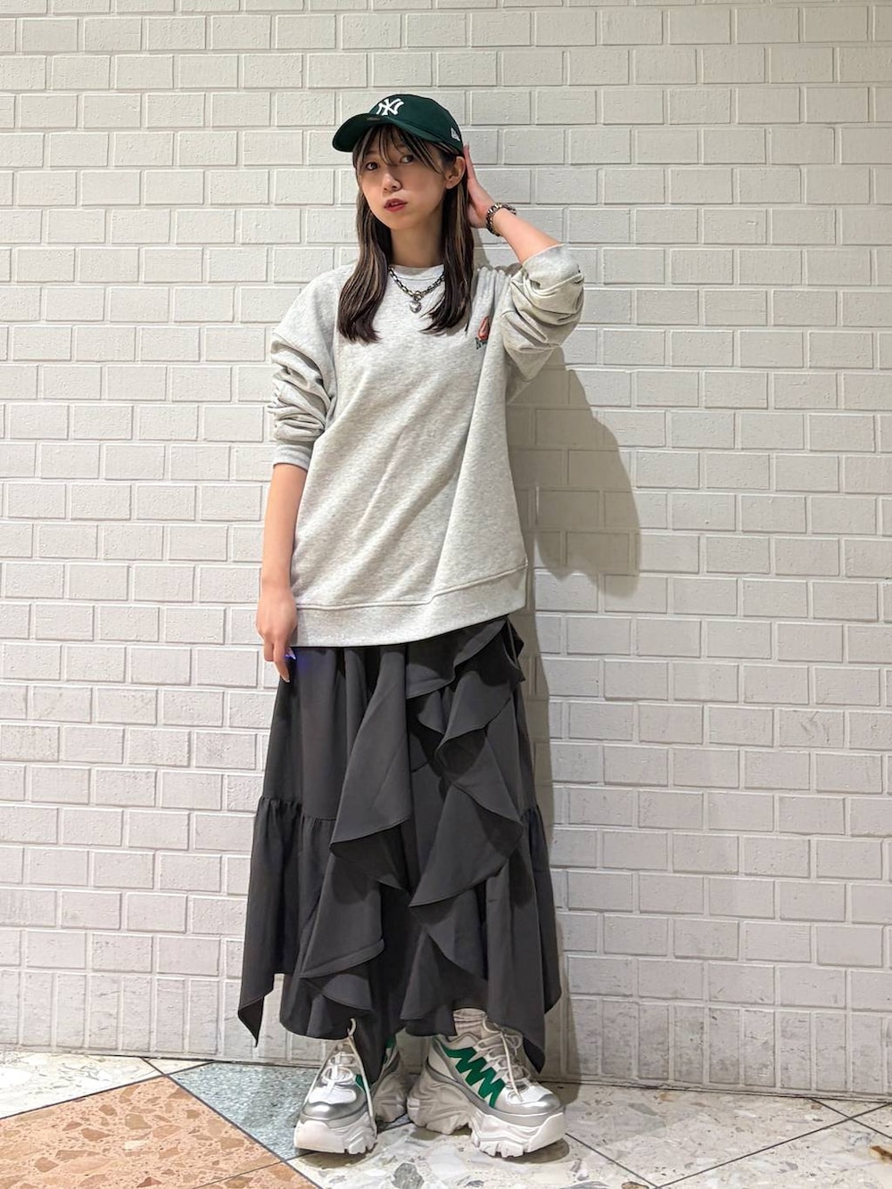 ホワイト系のスニーカー、グレー系のスカート、グレー系のスウェットを着用したレディースの春コーディネートの4枚目の写真
