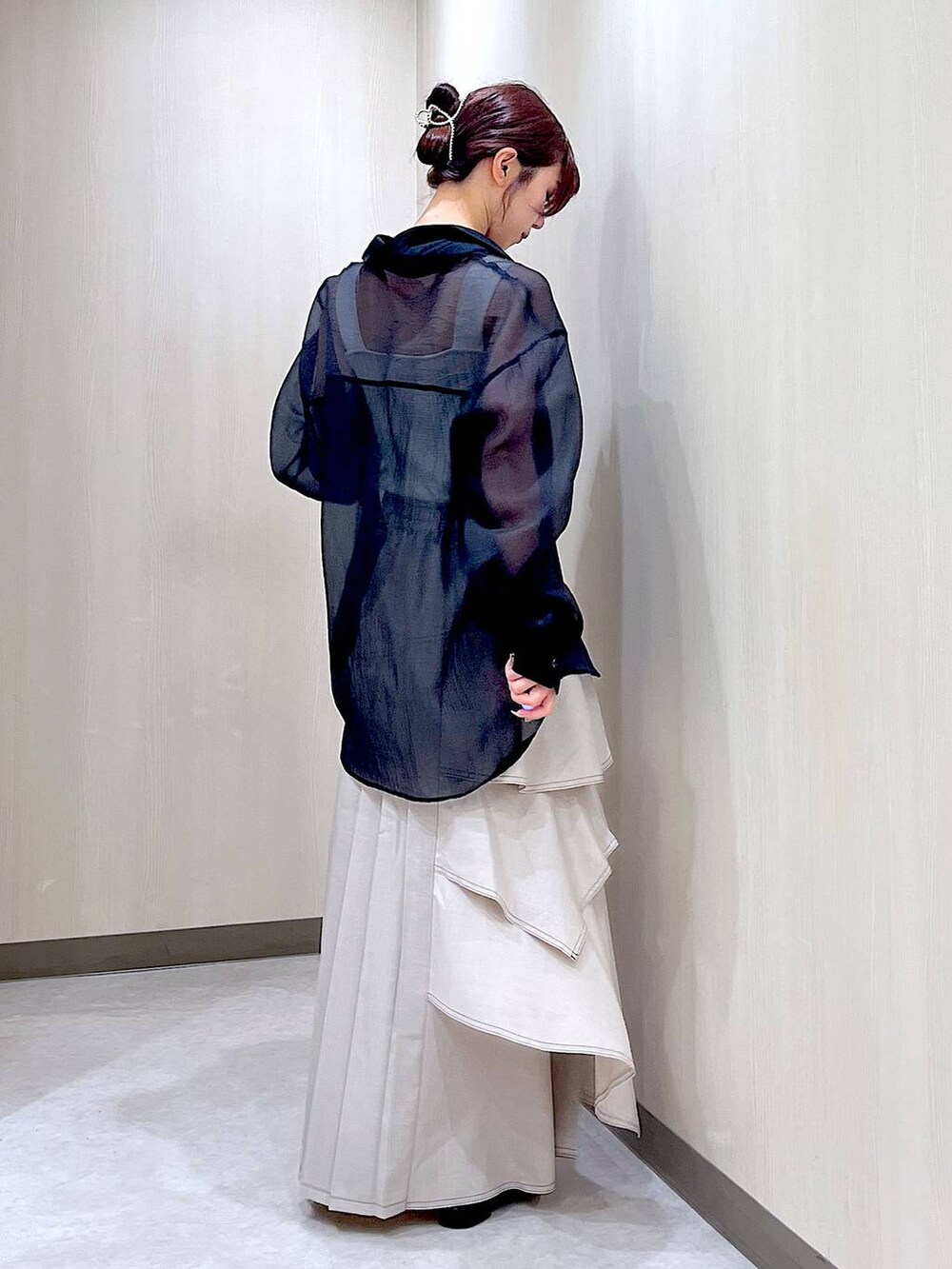 ブラック系のパンプス、ブラック系のシャツ/ブラウス、グレー系のスカートを着用したレディースの秋コーディネートの4枚目の写真