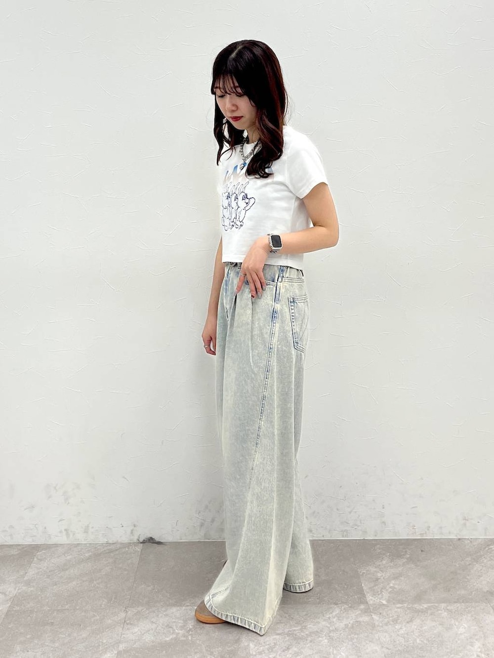 ブルー系のデニムパンツ、ホワイト系のTシャツ/カットソー、ブラウン系のベルトを着用したレディースの春コーディネートの4枚目の写真