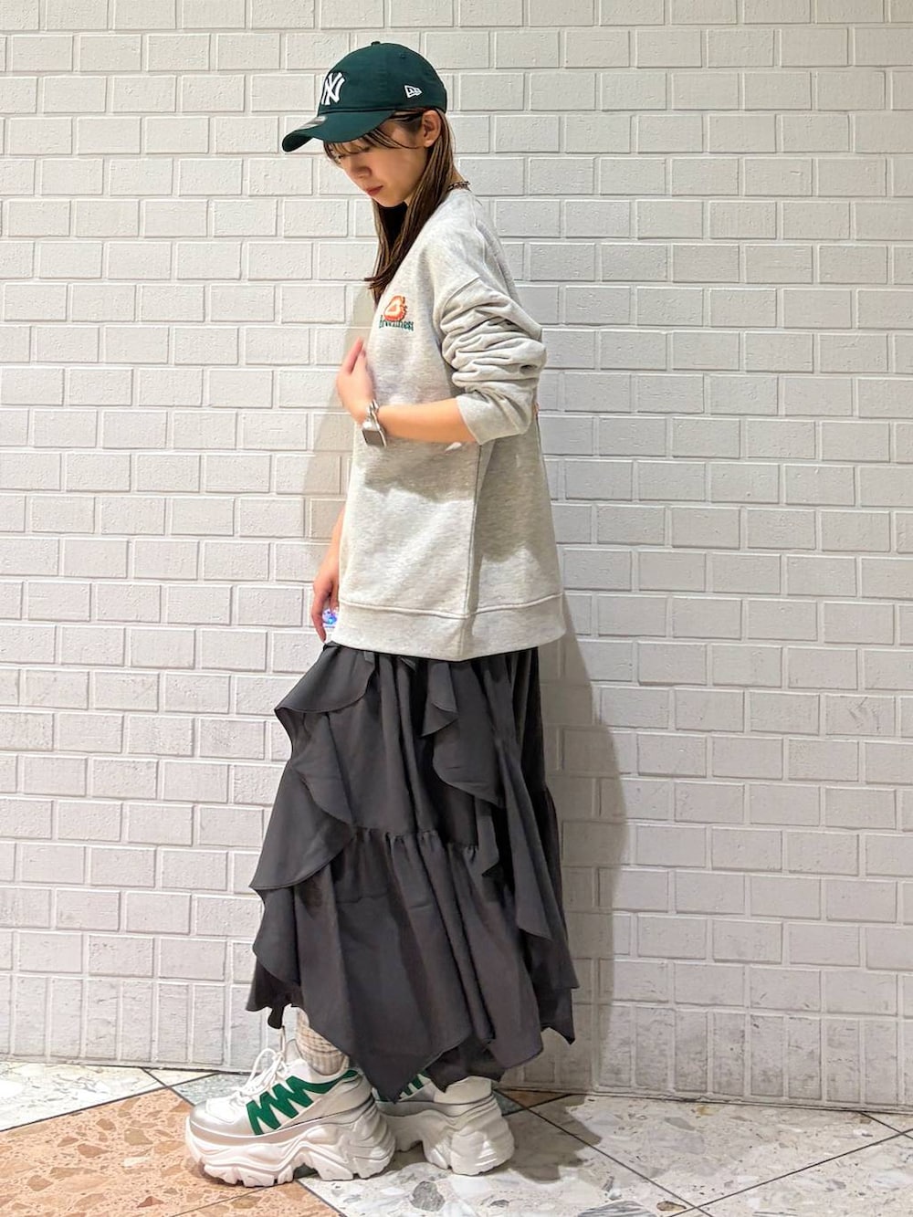 ホワイト系のスニーカー、グレー系のスカート、グレー系のスウェットを着用したレディースの春コーディネートの6枚目の写真