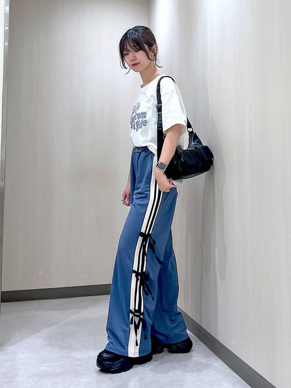 ブラック系のスニーカー、ベージュ系のTシャツ/カットソー、ブルー系のその他パンツを着用したレディースの夏コーディネートの2枚目の写真