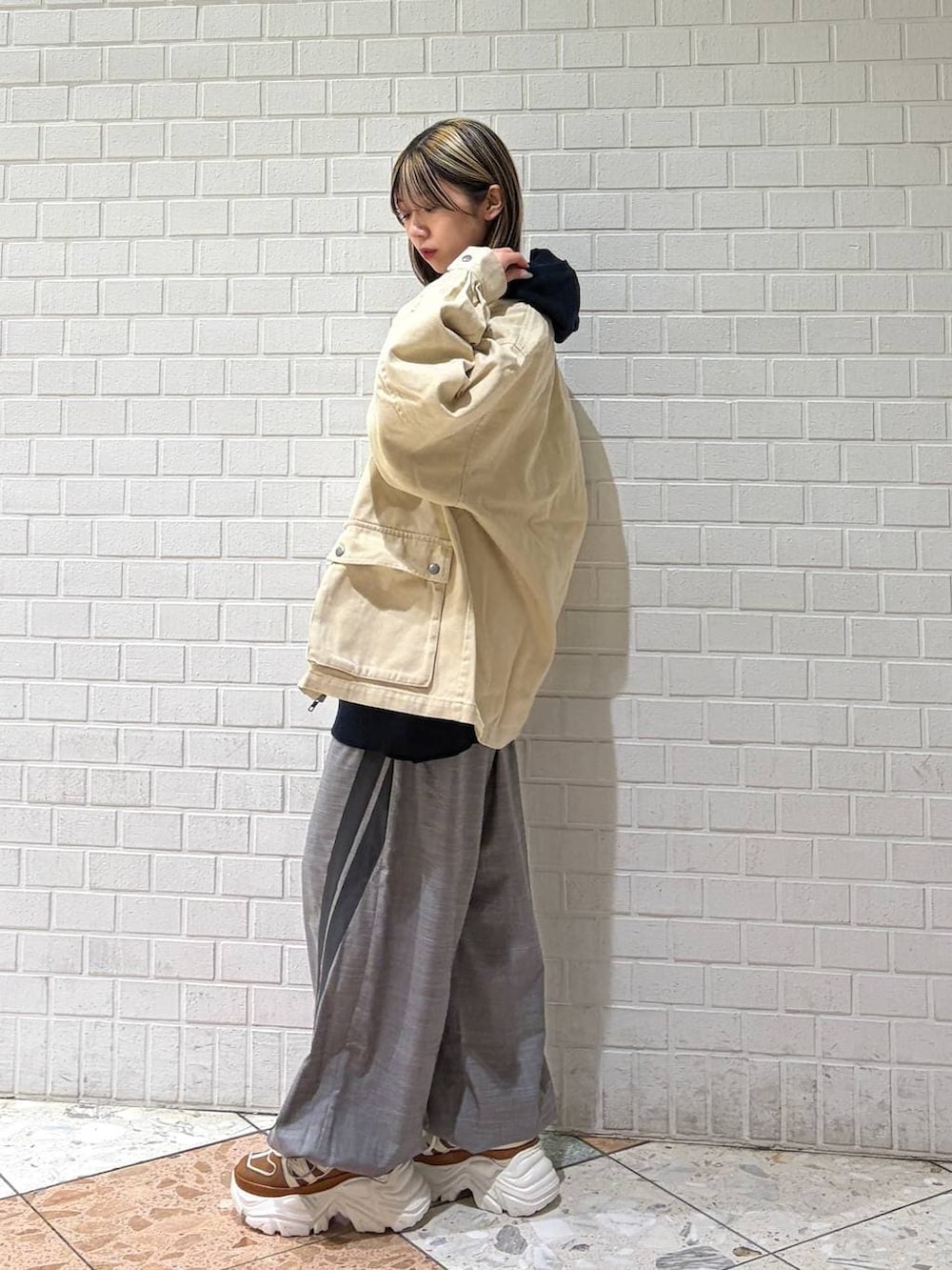ベージュ系のスニーカー、ブルー系のパーカー、グレー系のその他パンツを着用したレディースの春コーディネートの2枚目の写真