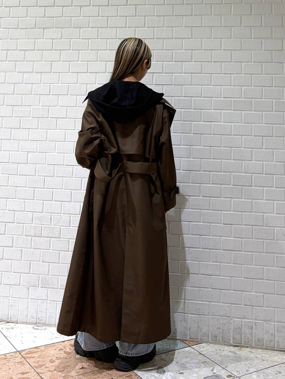 ブラック系のブーツ、ブラウン系のトレンチコート、ブルー系のデニムパンツを着用したレディースの春コーディネートの8枚目の写真