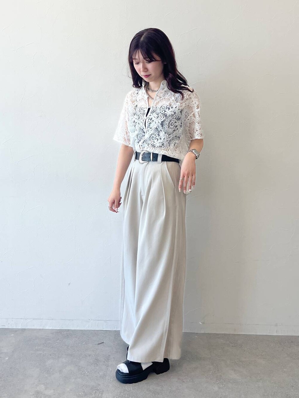 ホワイト系のシャツ/ブラウス、ブラック系のサンダル、ベージュ系のスラックスを着用したレディースの春コーディネートの4枚目の写真